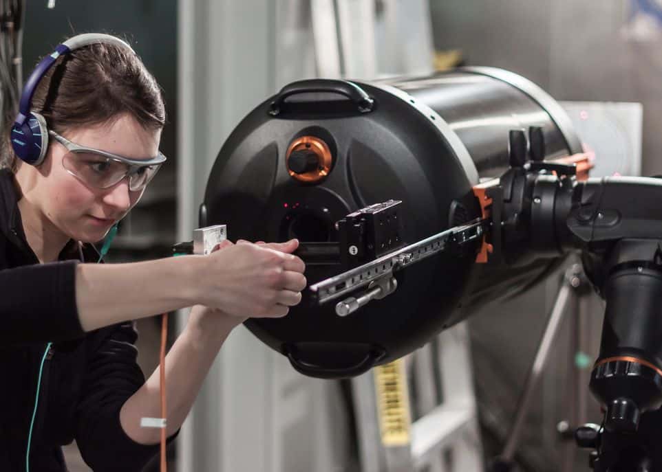 Mireille Ouellet, étudiante à la maîtrise en physique, apporte quelques ajustements au télescope. © Guillaume Allain, Université Laval