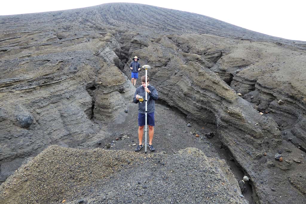 Un étudiant de la SEA effectue un relevé de position GPS au creux d'une des nombreuses ravines découpées par les précipitations sur les flancs du cône volcanique. Elles atteignent presque deux mètres de profondeur. © Dan Slayback