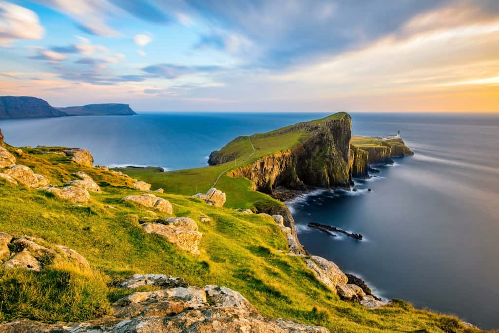 Au loin, le phare de Neist Point, sur l'île de Skye qui est la plus grande île de l'archipel des Hébrides intérieures, au nord-ouest de l'Écosse. © _Danoz, Adobe Stock