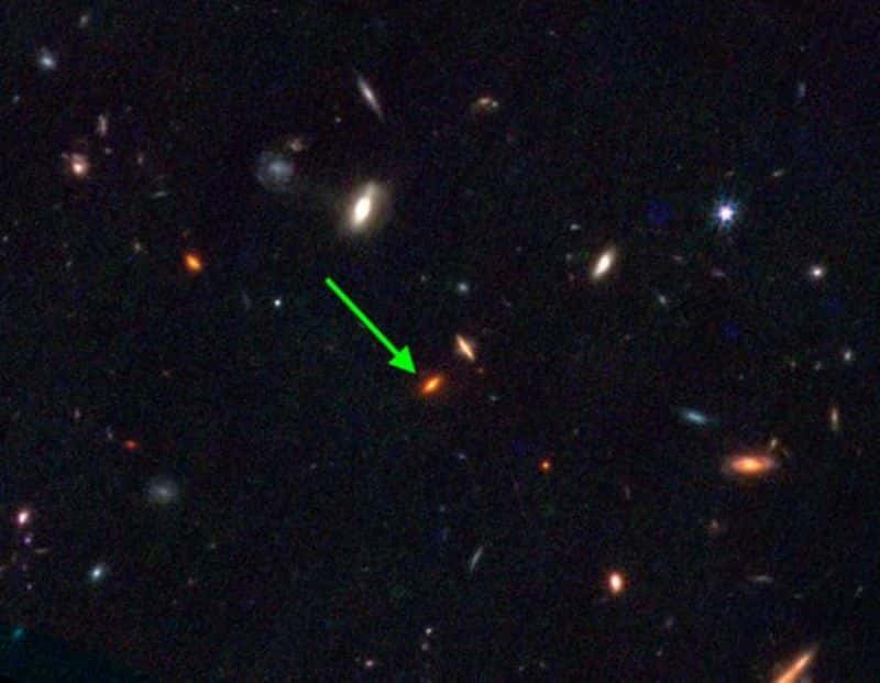 JWST-7329 : une galaxie massive rare qui s'est formée très tôt dans l'Univers. Cette image JWST NIRCam montre une galaxie à disque rouge, mais avec des images seules, il est difficile de la distinguer des autres objets. L’analyse spectrale de sa lumière avec JWST a révélé sa nature anormale : elle s’est formée il y a environ 13 milliards d’années, même si elle contient environ 4 fois plus de masse en étoiles que notre Voie lactée aujourd’hui. © <em>Swinburne University of Technology</em>