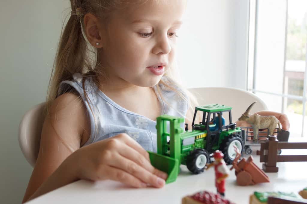 Manipuler des véhicules miniatures permet à l'enfant d’accroître sa compréhension du monde qui l’entoure. © lisssbetha, Adobe Stock