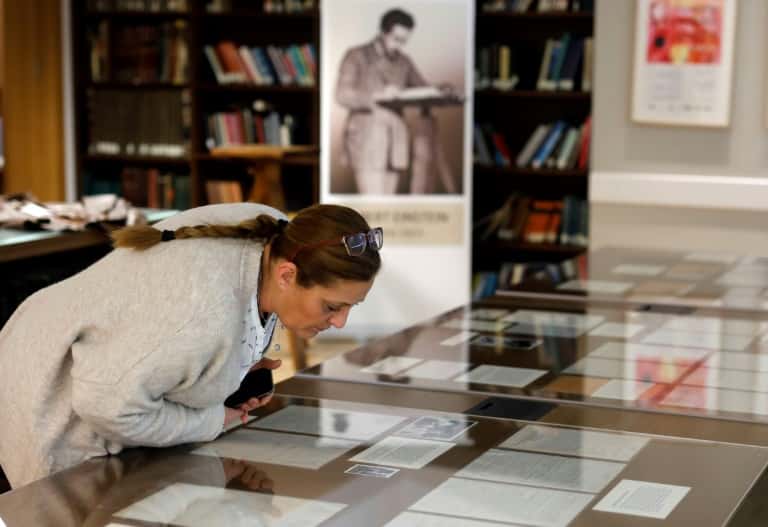 Une femme examine des pages manuscrites d'Albert Einstein exposées à l’université hébraïque de Jérusalem, le 6 mars 2019. © Menahem Kahana, AFP