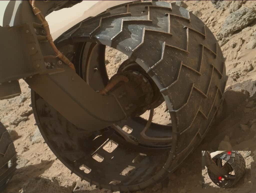 Une des roues mal en point du rover Curiosity. Les marques rouges sur la petite image indiquent deux perforations dont une déchirure, en bas, plutôt inquiétante. © Nasa/JPL