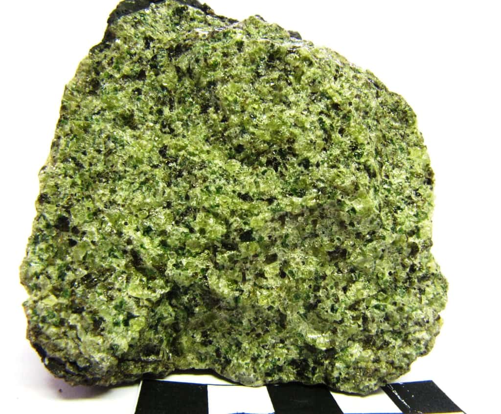 La lherzolite est une roche grenue se composant de 40 à 90 % d'olivine, qui lui donne sa couleur verte. Elle fait partie des péridotites, vaste famille composant une grande partie du manteau supérieur terrestre. (Plus précisément, cette image montre une enclave de péridotite de type lherzolite à spinelle dans une bombe basaltique.) © ENS Lyon