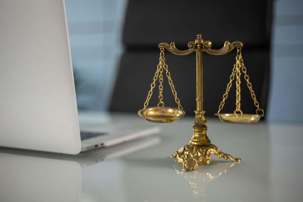 La balance la Justice à côté d'un ordinateur ©Pexels - Katrin Bolovtsova