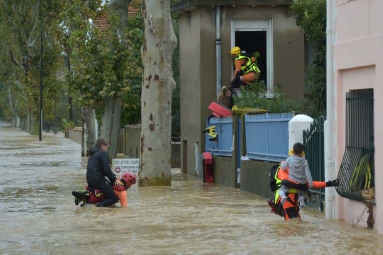 Des pompiers évacuent des personnes dans une zone inondée de Trèbes, près de Carcassonne, le 15 octobre 2018 dans l’Aude. © Pascal PAVANI, AFP