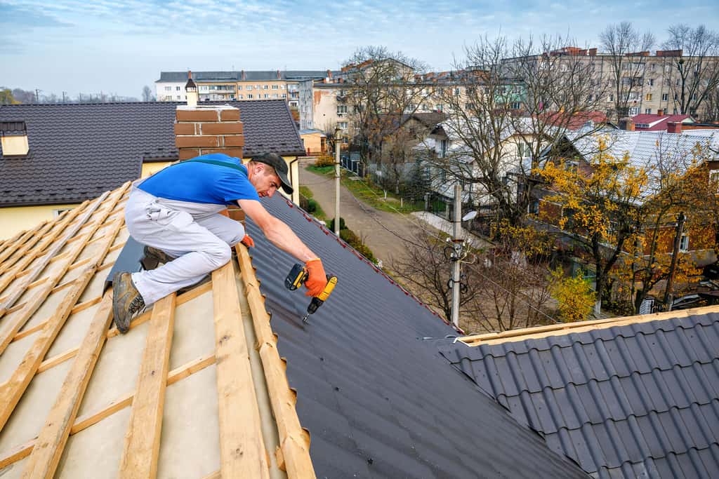 Pose d'une toiture par un artisan couvreur professionnel. © Volodymyr Shevchuk, Adobe Stock