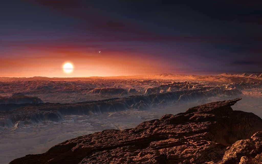 Cette représentation d’artiste montre une vue de la surface de la planète Proxima b en orbite autour de la naine rouge Proxima du Centaure, l’étoile la plus proche du Système solaire. Le système d’étoiles doubles Alpha Centauri AB figure dans l’angle supérieur droit de l’image. Proxima b est dotée d’une masse légèrement supérieure à celle de la Terre et décrit une orbite autour de Proxima Centauri, au sein même de la zone d’habitabilité de cette étoile, de sorte que sa température de surface est compatible avec la présence d’eau liquide. © M. Kornmesser, ESO