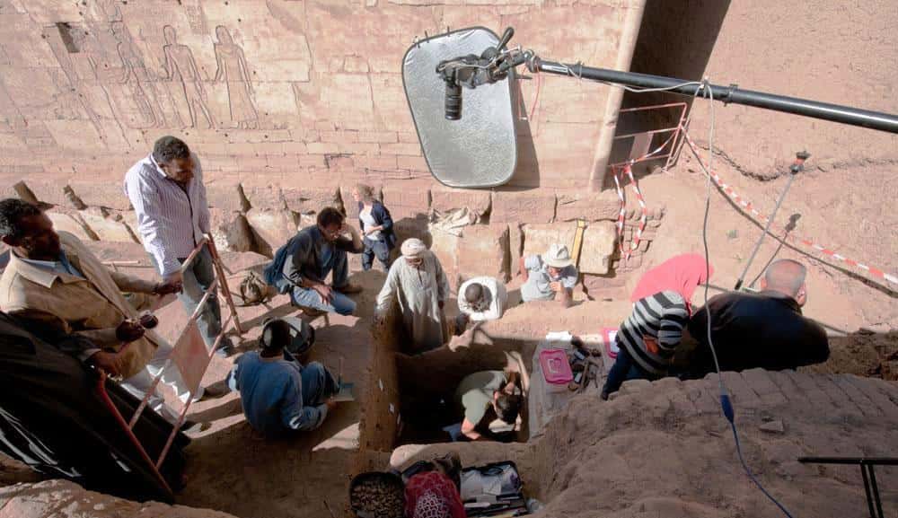 Les archéologues au mois de décembre 2014, en plein travail à l’est du temple de Ptah à Karnak. Ils déterrent des objets jetés pêle-mêle dans une fosse, autour de la partie inférieure d’une statue en calcaire du dieu Ptah. © CFEETK, CNRS