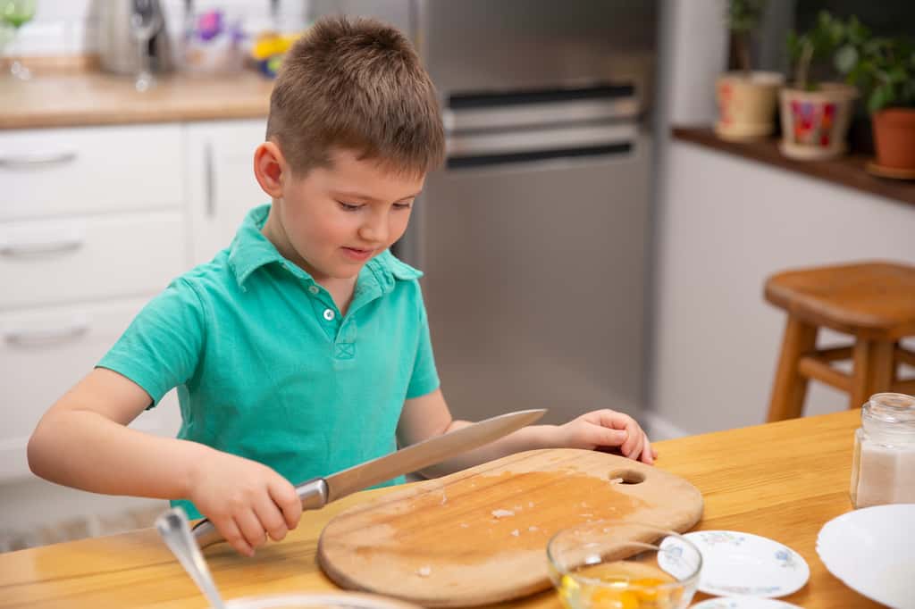 Ne laissez pas votre enfant manipuler des couteaux tranchants. Confiez-lui des tâches moins dangereuses ! © Volodymyr Shcerbak, Adobe Stock