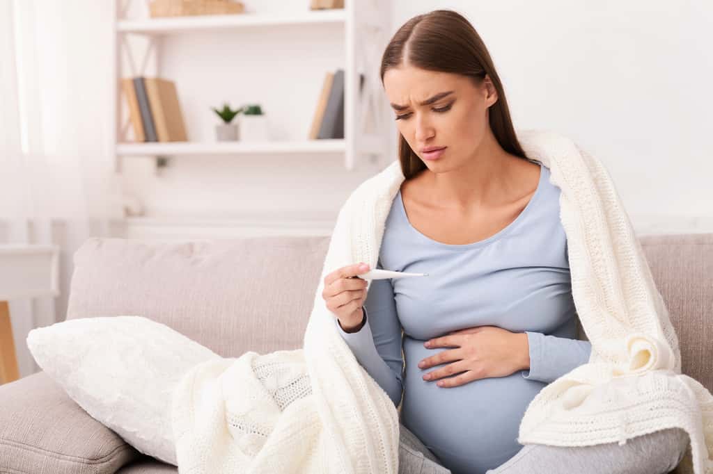 La grossesse rend les femmes plus sensibles aux infections. Dès le moindre symptôme, comme la fièvre, il faut contacter un médecin. © Prostock-studio, Adobe Stock
