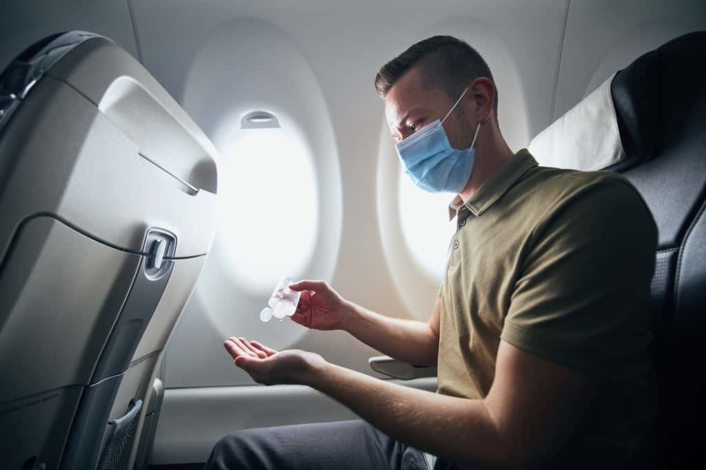 En avion, comme dans le quotidien, il reste conseillé de porter un masque et de se laver les mains régulièrement. Même pour les personnes pleinement vaccinées. © Chalabala, Adobe Stock