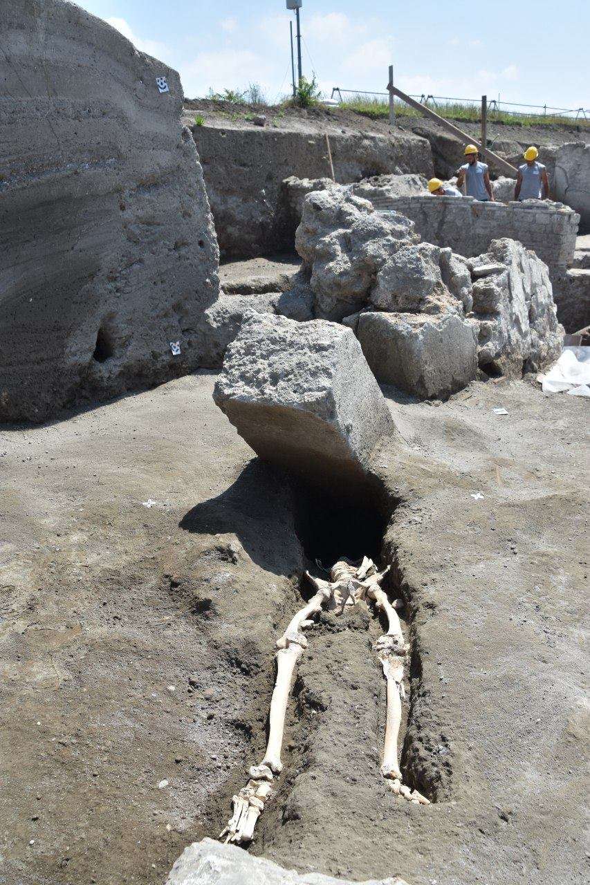 Souffrant d’une infection à la jambe, cet homme d’une trentaine d’années n’a pas eu le temps de fuir durant la destruction de Pompéi, il y a près de 2.000 ans. Il a péri violemment au cours de l’éruption du Vésuve. Le bloc de pierre l’a sans doute décapité. © <em>Pompeii, Parco Archeologico</em>