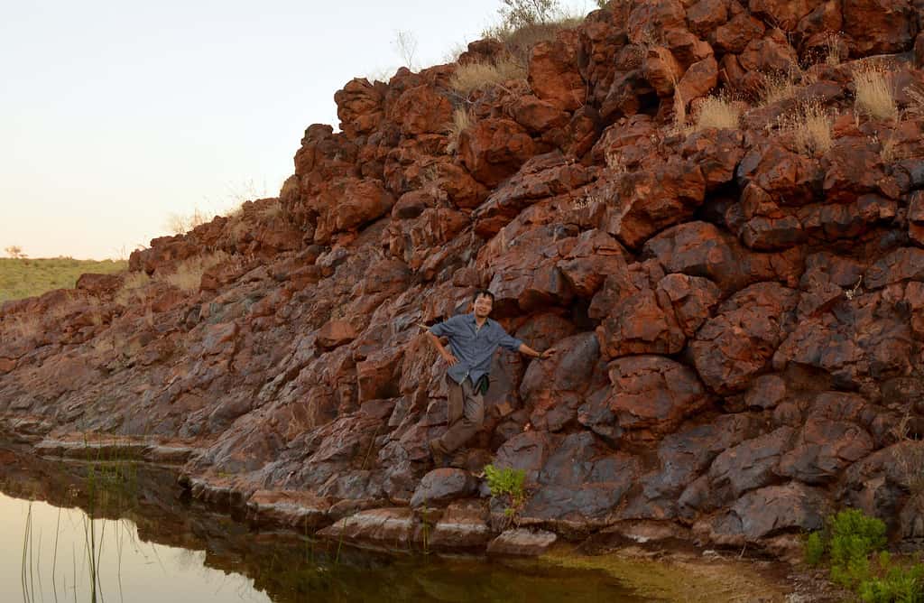 Le professeur Roger Fu pose sur un affleurement du basalte Honeyeater dans le Pilbara Craton en Australie occidentale. © Alec Brenner, <em>Harvard University</em> 