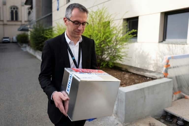 Le professeur Tristan Ferry porte des boîtes contenant des virus phages le 8 mars 2019 à l'hôpital lyonnais de la Croix-Rousse. © Romain Lafabregue – AFP
