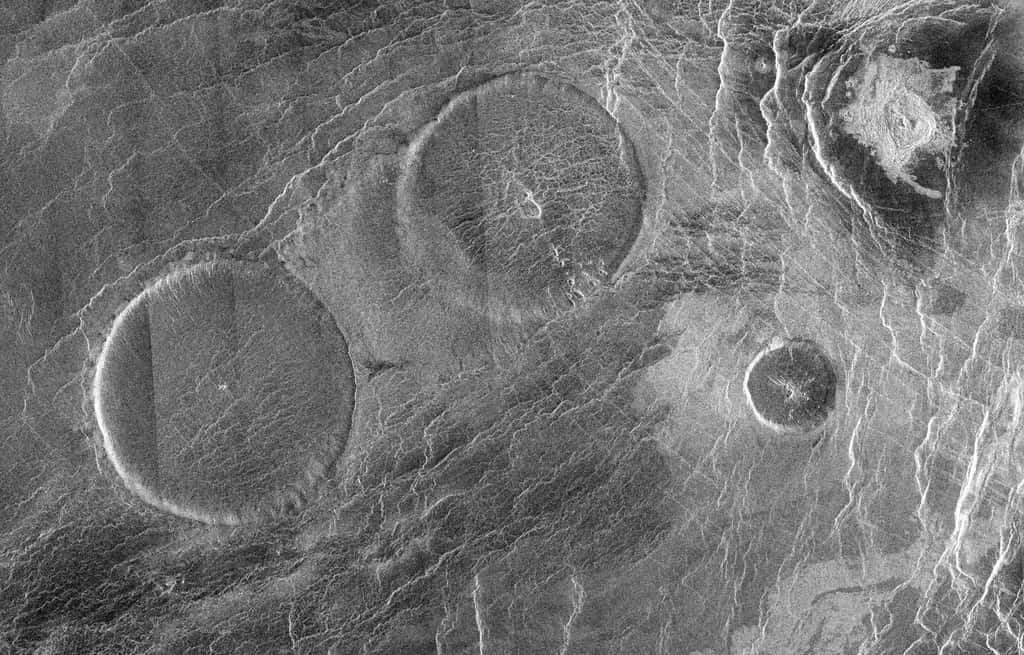 Cette mosaïque d'images radar de Magellan pleine résolution, centrée à 12,3 degrés de latitude nord et 8,3 degrés de longitude est, montre une zone de 160 km sur 250 km dans la région d'Eistla de Vénus. Les éléments circulaires proéminents sont des dômes volcaniques de 65 kilomètres de diamètre avec des sommets larges et plats de moins d'un kilomètre de hauteur. Parfois appelés dômes « en crêpe », ils représentent une catégorie unique d'extrusions volcaniques sur Vénus formées à partir de lave visqueuse. Les fissures que l'on trouve couramment dans ces formations résultent du refroidissement et du retrait de la lave. Un flux moins visqueux a été émis du dôme nord-est vers l’autre grand dôme situé dans le coin sud-ouest de l’image. © Nasa, JPL