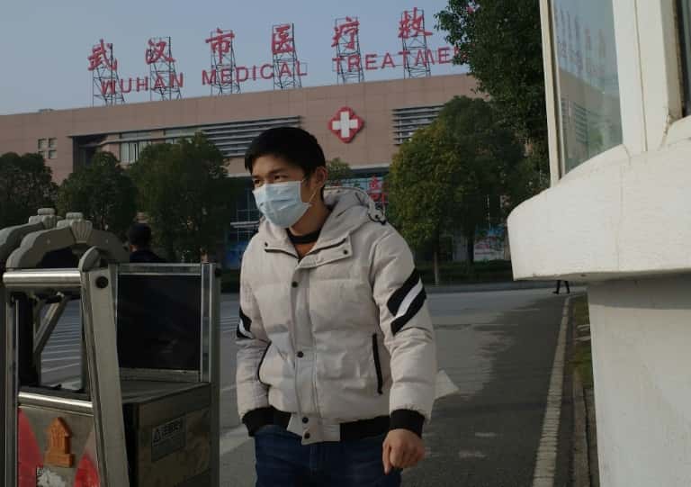 Un jeune homme sort du centre médical de Wuhan, le 12 janvier 2020 en Chine, où un homme est décédé d'un virus appartenant à la même famille que le Sras. © Noel Celis, AFP