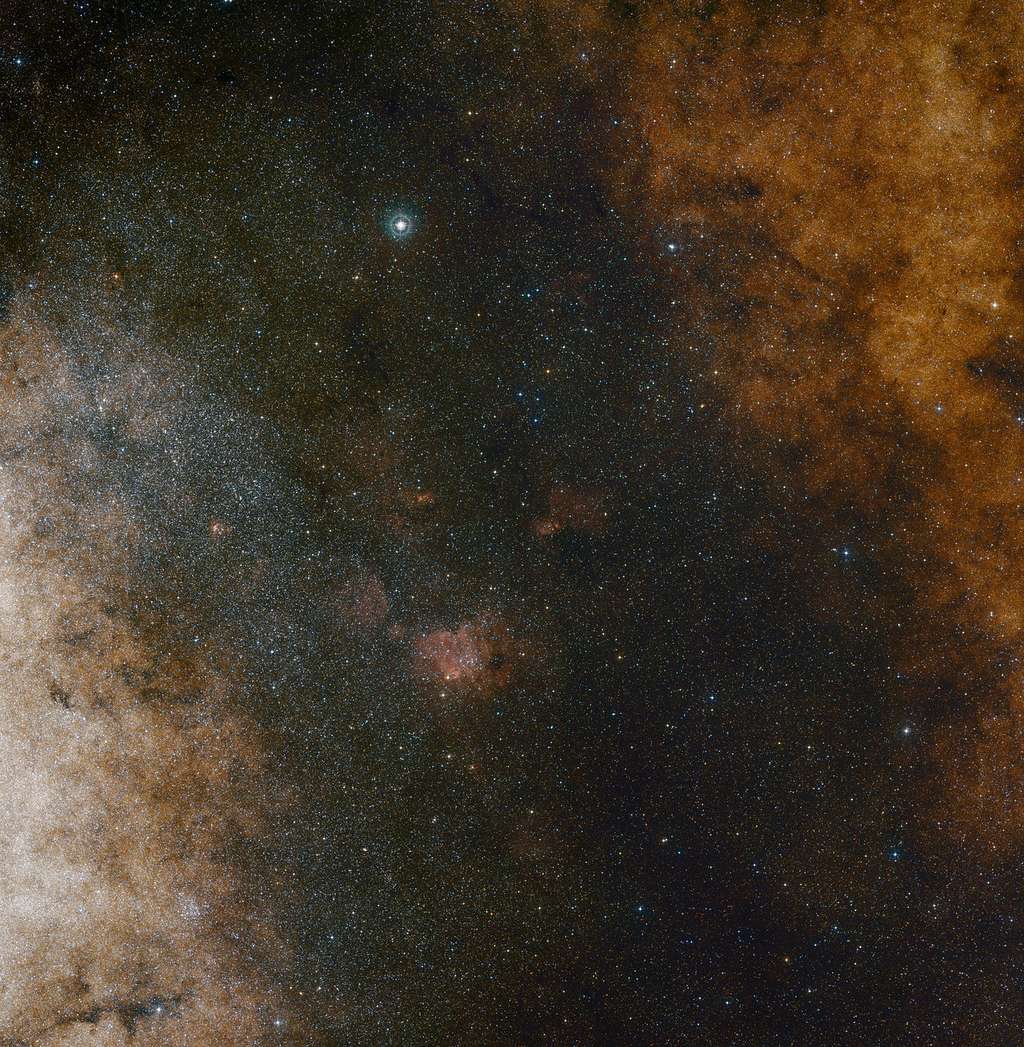 Cette vue à champ large dans le domaine visible montre les riches amas d’étoiles qui peuplent la constellation du Sagittaire dans la direction du centre de notre galaxie, la Voie lactée. La totalité de l’image est emplie de très nombreuses étoiles – bon nombre d’entre elles toutefois sont masquées par des nuages de poussière et ne révèlent leur présence que dans le domaine infrarouge. Cette vue a été constituée à partir de photographies acquises dans les longueurs d’onde rouge et bleue issues du <em>Digitized Sky Survey 2</em>. Le champ de vue est voisin de 3,5 degrés x 3,6 degrés. © <em>ESO and Digitized Sky Survey 2. Acknowledgment: Davide De Martin and S. Guisard</em>