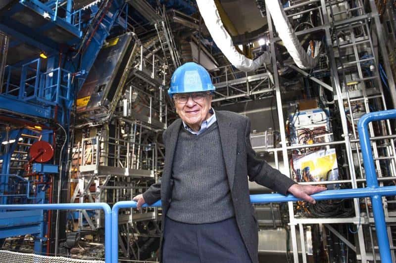 Murray Gell-Mann en visite au Cern en janvier 2013. Le prix Nobel de physique se tient devant le détecteur Atlas. C'est l'un des principaux architectes du modèle standard des particules élémentaires notamment parce qu'il a prédit la structure en quark des hadrons. Ses travaux portent aussi sur la cosmologie quantique, et il est à l'origine de l'institut de Santa Fe (<em>Santa Fe Institute</em>, ou SFI), un institut de recherche spécialisé dans l'étude des systèmes complexes. © Maximilien Brice, Cern 