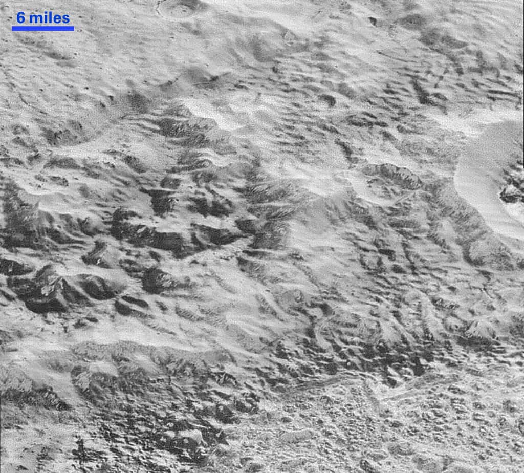 Une image d'une région de Pluton faisant penser aux badlands sur Terre. La barre en haut à gauche donne l'échelle qui est d'environ 9,6 kilomètres (6 miles). La largeur de l'image est d'environ 80 kilomètres. © Nasa, JHUAPL, SwRI
