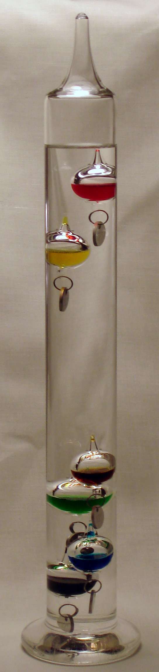 Le thermomètre de Galilée, plus décoratif que précis, contient des bulles de densités différentes : elles coulent une à une en fonction de la température du liquide dans lequel elles baignent. © Ali@gwc.org.uk, Wikipedia, CC by-sa 2.5
