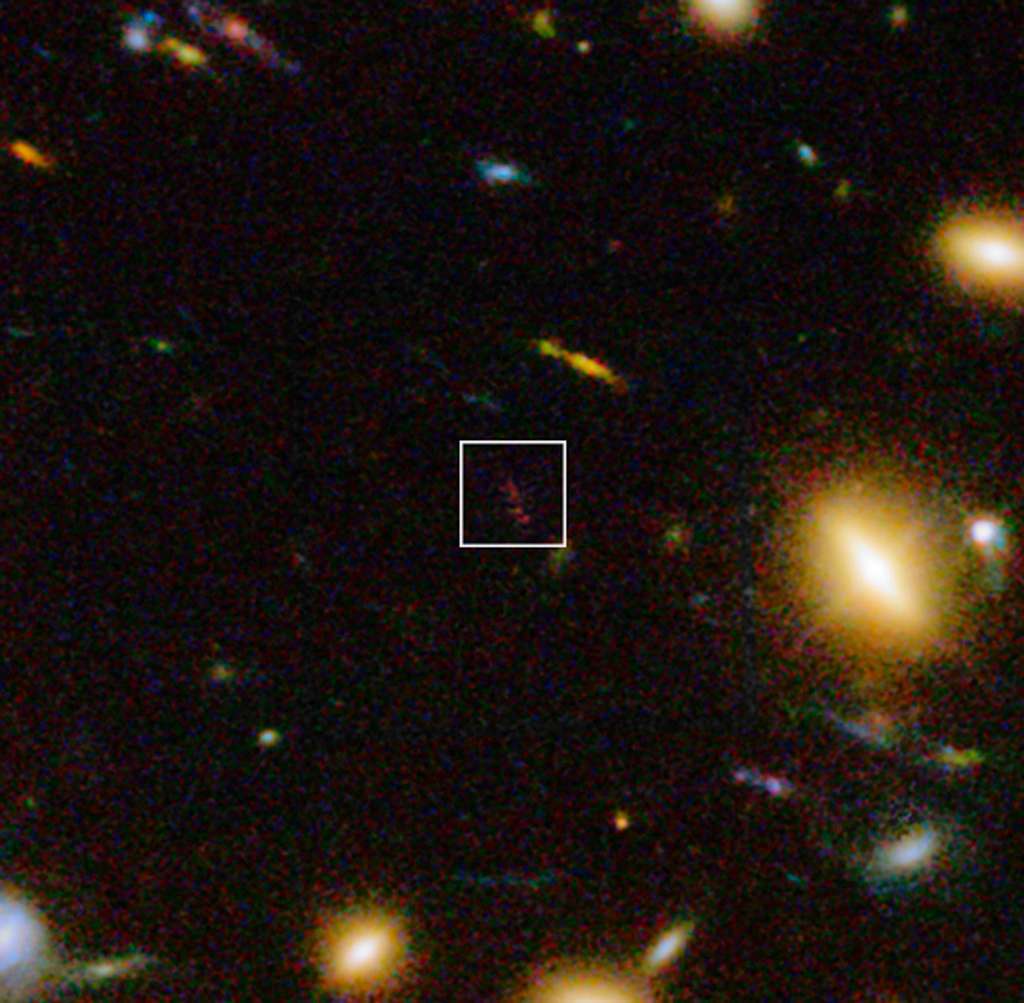 Sur cette image acquise dans le visible et l’infrarouge avec la caméra WFC3 d’Hubble, gros plan dans l’amas galactique Abell 1689 sur l’objet A1689-zD1 situé à un peu plus de 13 milliards d’années-lumière de notre galaxie, la Voie lactée. Les nouvelles observations effectuées au moyen d'Alma et du VLT ont montré qu’il s’agit d’une galaxie poussiéreuse qui nous apparaît telle qu'elle était lorsque l’univers était âgé d’environ 700 millions d'années. © Eso, J. Richard