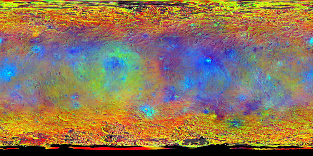 Planisphère de Cérès composé d’images en fausses couleurs réalisées à travers les filtres infrarouge (920 nm), rouge (750 nm) et bleu (440 nm) de l’un des spectromètres de Dawn. Au-delà de sa teinte apparente uniforme dans le visible, la planète naine affiche ici les différences <em>« subtiles »</em> de la réflectivité des terrains, trahissant une composition minéralogique variée. © Nasa, JPL-Caltech, UCLA, MPS, DLR, IDA