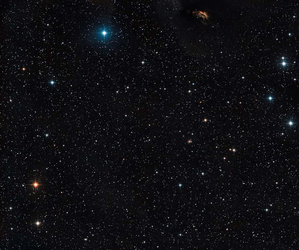 Cette vue étendue montre le ciel qui entoure le jeune système d’étoiles multiples GG Tauri, situé à proximité du centre de l’image. Les astronomes y voient également un nuage de poussière ainsi que la preuve de la formation d’étoiles dans la partie supérieure de l’image – GG Tau fait partie intégrante du Nuage sombre du Taureau. © Eso, DSS2, David De Martin