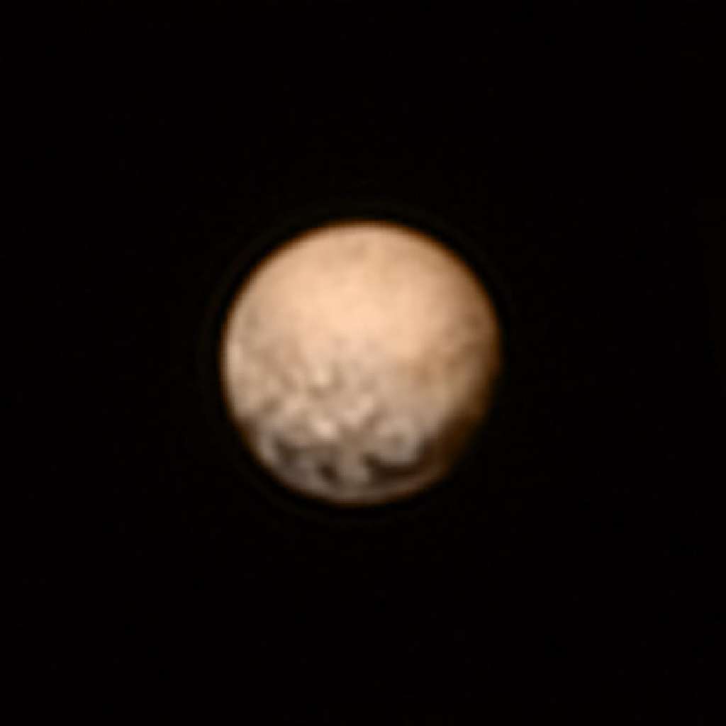 Image en couleurs de Pluton créée à partir de celle prise par le télescope Lorri de New Horizons, associée aux données obtenues avec l’instrument Ralph, quelques jours auparavant. Les grandes taches sombres visibles en bas chevauchent l’équateur de la planète naine. De nouveaux détails sont apparus au-dessus de cette région, à mesure que la sonde se rapproche. Des images à comparer avec celles d’<a href="//www.futura-sciences.com/magazines/espace/infos/actu/d/astronomie-image-telescope-hubble-cartographie-pluton-22529/" title="En image : le télescope Hubble cartographie Pluton">Hubble</a> réalisées en 2010. © Nasa, JHUAPL, SwRI