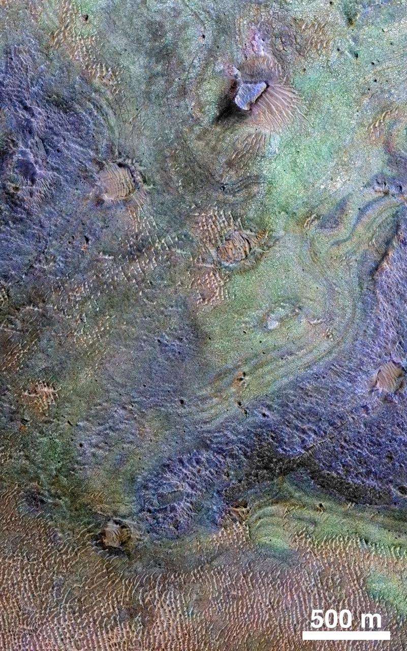 Image composite d’une partie de la région de <em>Nili Fossae</em>, le plus grand dépôt de carbonates connu à la surface de Mars, créée à partir des données de MRO (<em>Mars Reconnaissance Orbiter</em>). Les roches riches en carbone sont en vert. Le brun indique les sables riches en olivine, et le violet la présence de basalte. © Nasa, JPL-Caltech, JHUAPL, <em>University of Arizona</em>