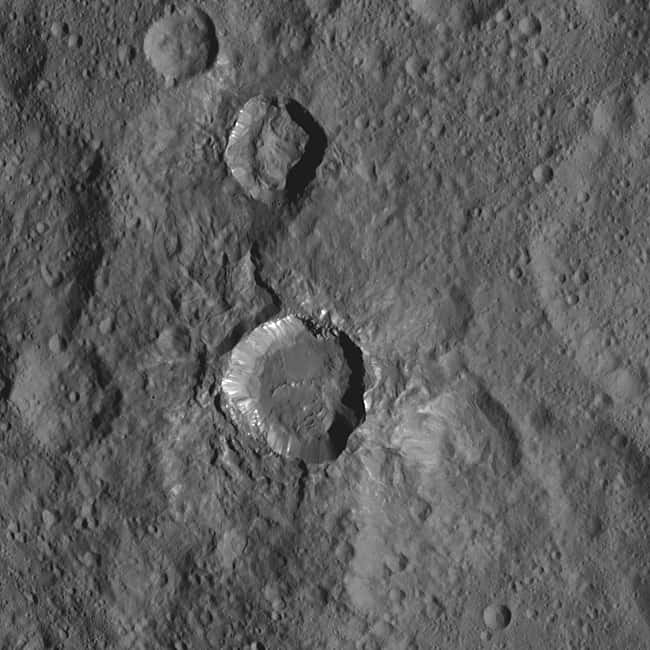 Cratère de 26 km de diamètre situé entre ceux de Fluusa et de Toharu. Les matériaux brillants sont notamment visibles sur ses parois. Plus de 130 taches blanches ont été identifiées à la surface de Cérès et la plupart sont dans ou autour de cratères d’impact. © Nasa, JPL-Caltech, UCLA, MPS, DLR, IDA