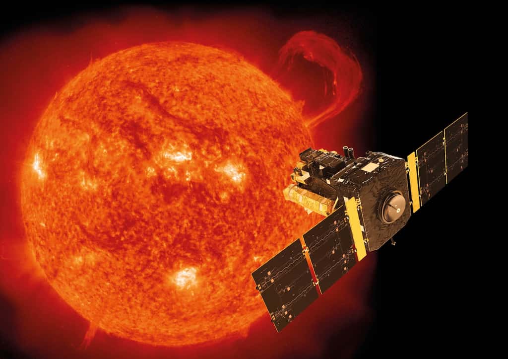 Illustration de Soho superposée à une image de notre étoile prise par le satellite le 14 septembre 1999 avec l’instrument EIT (<em>Extreme-ultraviolet Imaging Telescope</em>). Ce jour-là, une gigantesque protubérance en forme de poignet se développait sur le limbe du Soleil. Le pic d’activité du cycle 23 allait alors débuter. © Soho, Esa, Nasa, ATG medialab