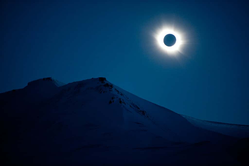 Au-dessus des reliefs enneigés de l’archipel de Svalbard, en Norvège, la Lune a totalement recouvert le Soleil, imposant la nuit et laissant voir la couronne solaire. © Epa-Olav, Jon Nesvold