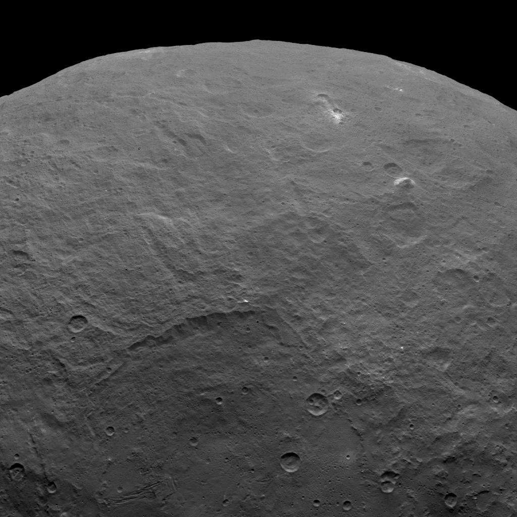 Sur cette image prise par Dawn le 6 juin 2015, à 4.400 km au-dessus de la surface de Cérès, on remarque plusieurs points brillants et aussi la présence d’une montagne pyramidale aux pentes abruptes. Elle culmine à environ 5.000 mètres. © Nasa, JPL-Caltech, UCLA, MPS, DLR, IDA