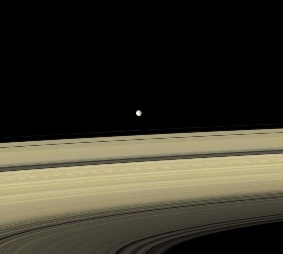 Mimas est un des satellites naturels sphériques les plus proches de Saturne. Bien que photographié par Cassini à plus de 3 millions de km de distance, le cratère Herschel qui domine la surface de cette petite lune se remarque sans difficulté. © Nasa, JPL, <em>Space Science Institute</em>