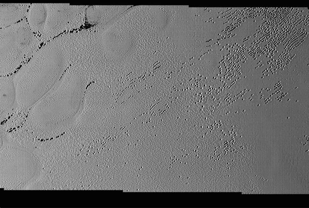 Cette image très détaillée prise avec Lorri montre une multitude de trous de plusieurs centaines de mètres de large entre les cellules de glace au sein de la plaine Spoutnik. Certains semblent moins profonds et beaucoup ont fusionné. La largeur de ce paysage photographié le 14 juillet est de 210 km. © Nasa, JHUAPL, SwRI