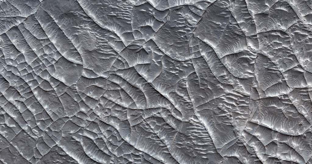 Nous nous trouvons désormais dans le sud-ouest d’Arabia Terra, avec une vue d’altitude de la surface martienne. Il y a 1 km entre le haut de l’image et le bas. Ici, encore, le terrain apparaît très accidenté. Les linéations visibles sont des rides de matériel rocheux plus résistant à l’érosion que le reste du terrain. © Nasa/JPL/UArizona