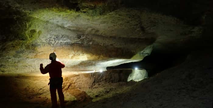 Dimitri Laurent explore l'une des galeries du gouffre Nébélé dans les Pyrénées. Cette grotte aurait été façonnée par l'action de l'acide sulfurique. Les parois sont couvertes de sulfate de sodium, résultant de l'altération des roches par l'acide sulfurique. © Christophe Durlet, CC BY-NC