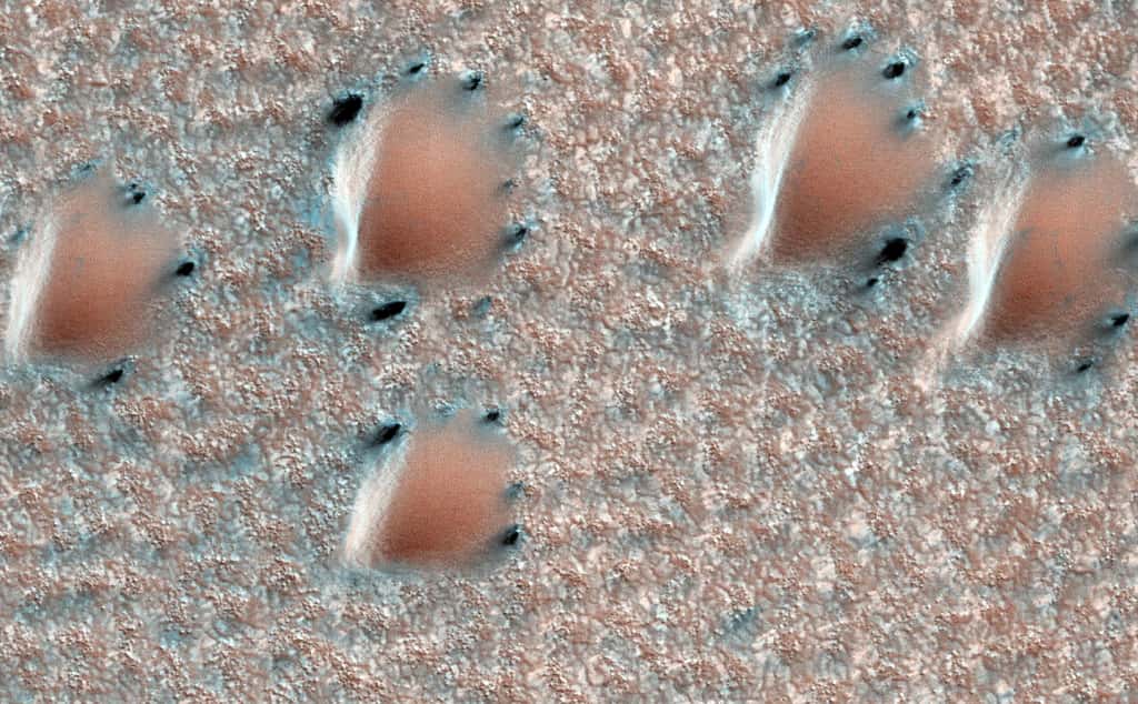 En 2011, Mars Reconnaissance Orbiter a capturé cette étonnante image. On y voit des dunes ressortant sur le fond recouvert d'une fine couche de glace. Les points noirs entourant les dunes sont les marques laissées par la sublimation de la glace. © Nasa/JPL-Caltech/UA 