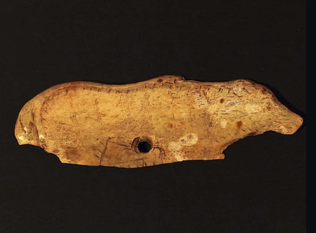 Un animal (un ours ?) gravé dans un os de cerf. Le trou percé suggère que l'objet devait être utilisé comme pendentif. © <em>Gabinete de Prensa del Gobierno de Cantabria</em>, <em>Wikimedia Commons</em>, CC by 3.0 ES 