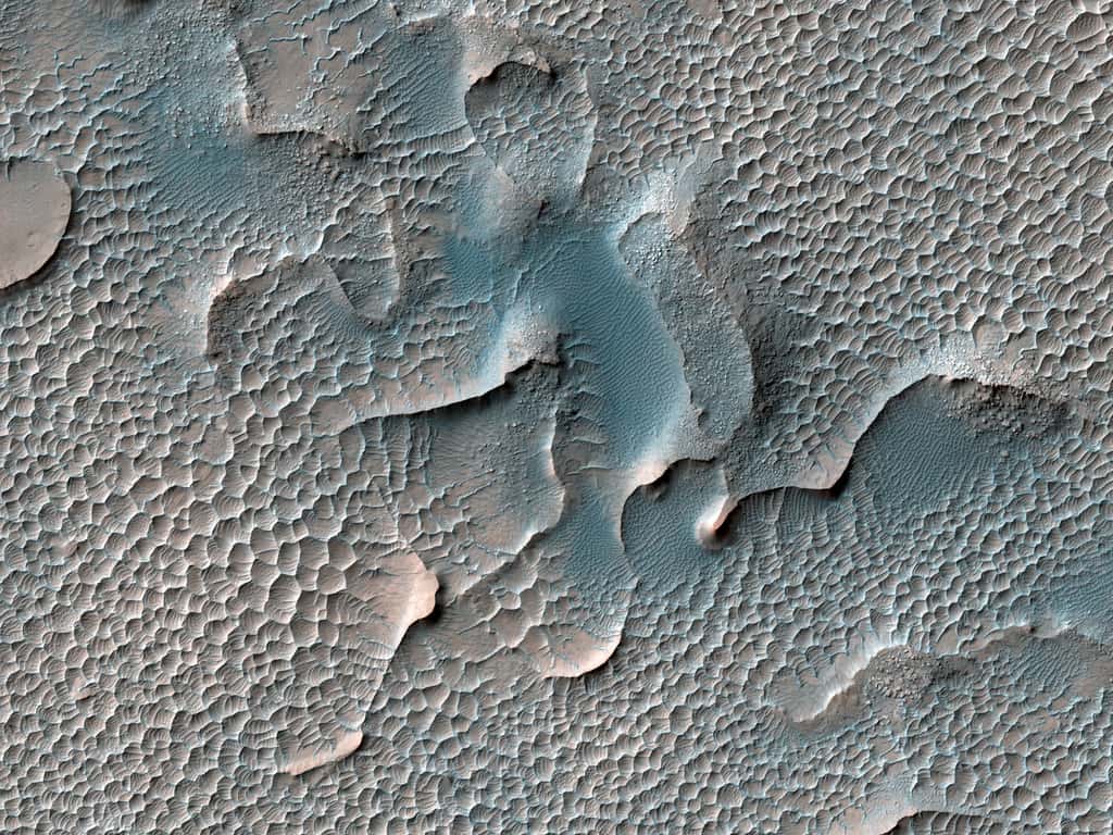 Ici, dans Melas Chasma, d’anciennes dunes, dont le matériel s’est induré au fil du temps, sont désormais elles-mêmes érodées pour former ce vaste champ de petites dunes. © Nasa/JPL/UArizona