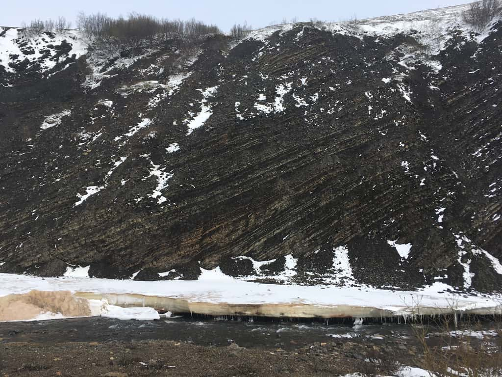 Paysage le long de la <em>Peel River</em> au Canada. On peut voir les roches exposées le long de la berge. L'érosion de la rivière met ainsi à l'affleurement d'importantes quantités de roches, dont les sulfures vont pouvoir réagir avec l'oxygène de l'atmosphère. © Robert Hilton 