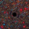 Image d’un trou noir supermassif au centre d’une galaxie simulée par ordinateur. Le rond noir figure l’horizon des événements, limite au-delà de laquelle toute matière ne peut plus s’échapper. Plus la masse de ce puits gravitationnel est grande, plus l’espace et le temps sont déformés, ce qui produit cet effet de miroir déformant sur les étoiles à l’arrière-plan. © Nasa, ESA, C.-P. Ma (University of California, Berkeley), J. Thomas (Max Planck Institute for Extraterrestrial Physics, Garching)