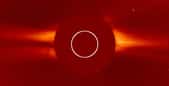 Le Soleil est au centre masqué par le coronographe Lasco C2 du satellite Soho. Image du 14 août 2020. On peut voir le vent solaire dépasser du disque. Le cercle blanc délimite la taille du Soleil. © Nasa, ESA, Soho