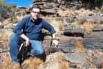 Le géologue Andrew Czaja indique la couche de roche dans laquelle des bactéries sulfureuses fossiles ont été découvertes en Afrique du Sud. © Aaron Satkoski