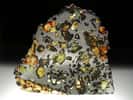 La météorite Esquel est une pallasite trouvée en 1951 dans la province de Chubut en Argentine. Ces météorites sont constituées d’une trame de fer et de nickel dans laquelle se détachent des grains d’olivine. © L. Carion, carionmineraux.com