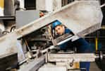 En atelier, le charpentier métallique fabrique et assemble les pièces métalliques qui seront ensuite transportées sur le chantier. Pour cela il utilise des machines à commande numérique et réalise des opérations de soudage. © Galdric, Adobe Stock.