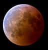 Les poussières dans l’atmosphère terrestre teintent en rouge sombre le cône d’ombre de notre Planète que reflète ici (à droite) la surface de la Lune, au cours de l’éclipse de mars 2007. L’autre moitié commence à y entrer. La couche d’ozone dans la haute atmosphère laisse une empreinte bleu clair, turquoise, visible à gauche. © Jens Hackman, Nasa