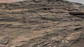 Cette photo est constituée de plusieurs images prises le 27 août 2015 (Sol 1.087) par les deux caméras du mât de Curiosity. Cette couche de grès, sur le Mont Sharp, actuellement explorée par le rover est nommée unité Stimson. On y voit des dunes de sable pétrifiées. Les lignes indiquent la direction des vents dominants. La balance des blancs a été travaillée de façon à faire apparaître le paysage sous un éclairage solaire comparable à celui de la Terre. Téléchargez l’image complète et en haute résolution ici (2,32 Mo). © Nasa, JPL-Caltech, MSSS