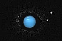 Cette image a été obtenue en combinant des observations faites en 2004 avec l'Advanced Camera for Surveys du télescope Hubble. Un masque occultant a été placé en face de Neptune pour réduire l'éblouissement de la planète lors d'un traitement d'image effectué sur ordinateur. Une autre image de Neptune, prise un mois auparavant, a été insérée par la suite. Naïade, la lune observée jadis par les instruments de Voyager 2, se trouve dans le cercle blanc à gauche. © Mark Showalter, Seti Institute